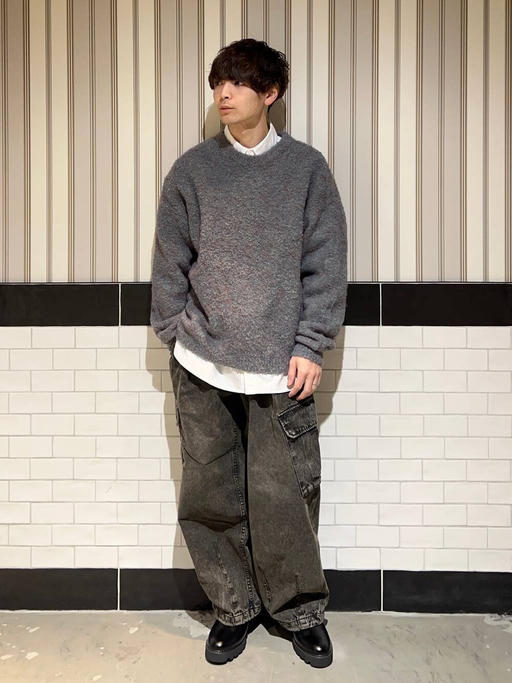 グリーン系のニット/セーター、ブラック系のドレスシューズ、ホワイト系のシャツ/ブラウスを着用したメンズの冬コーディネートの2枚目の写真