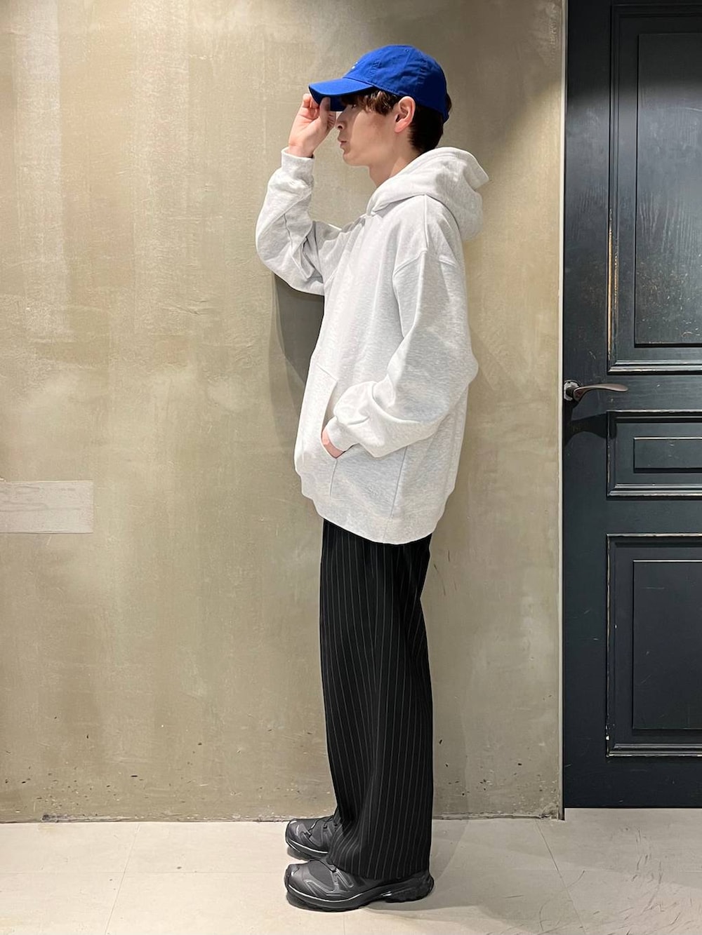 ブラック系のスニーカー、ブラック系のスラックス、その他のパーカーを着用したメンズの春コーディネートの4枚目の写真