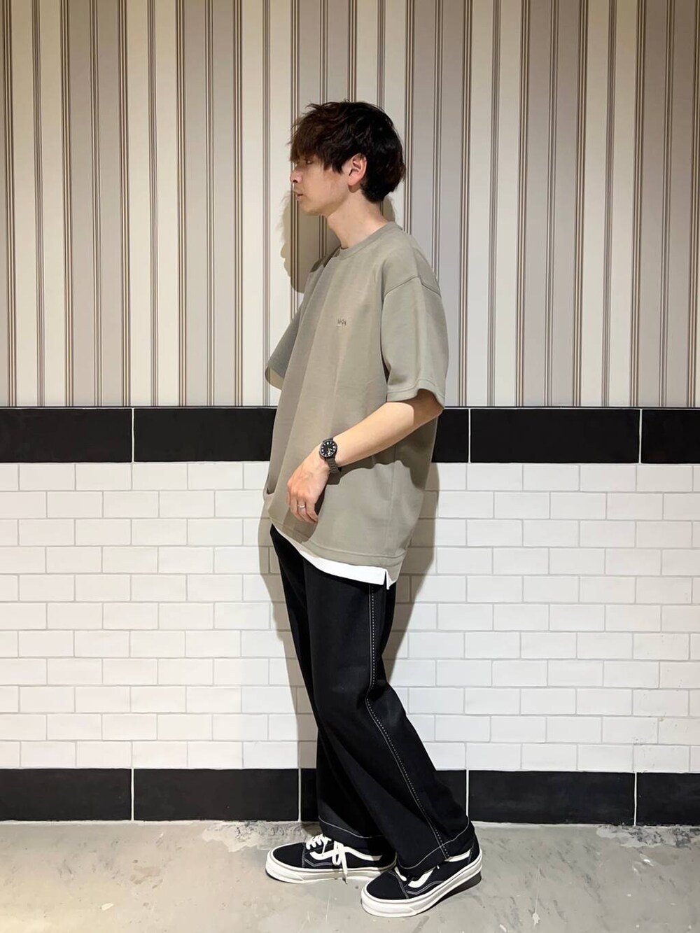 ホワイト系のタンクトップ、ブラック系のスラックス、ブラック系のスニーカーを着用したメンズの夏コーディネートの3枚目の写真