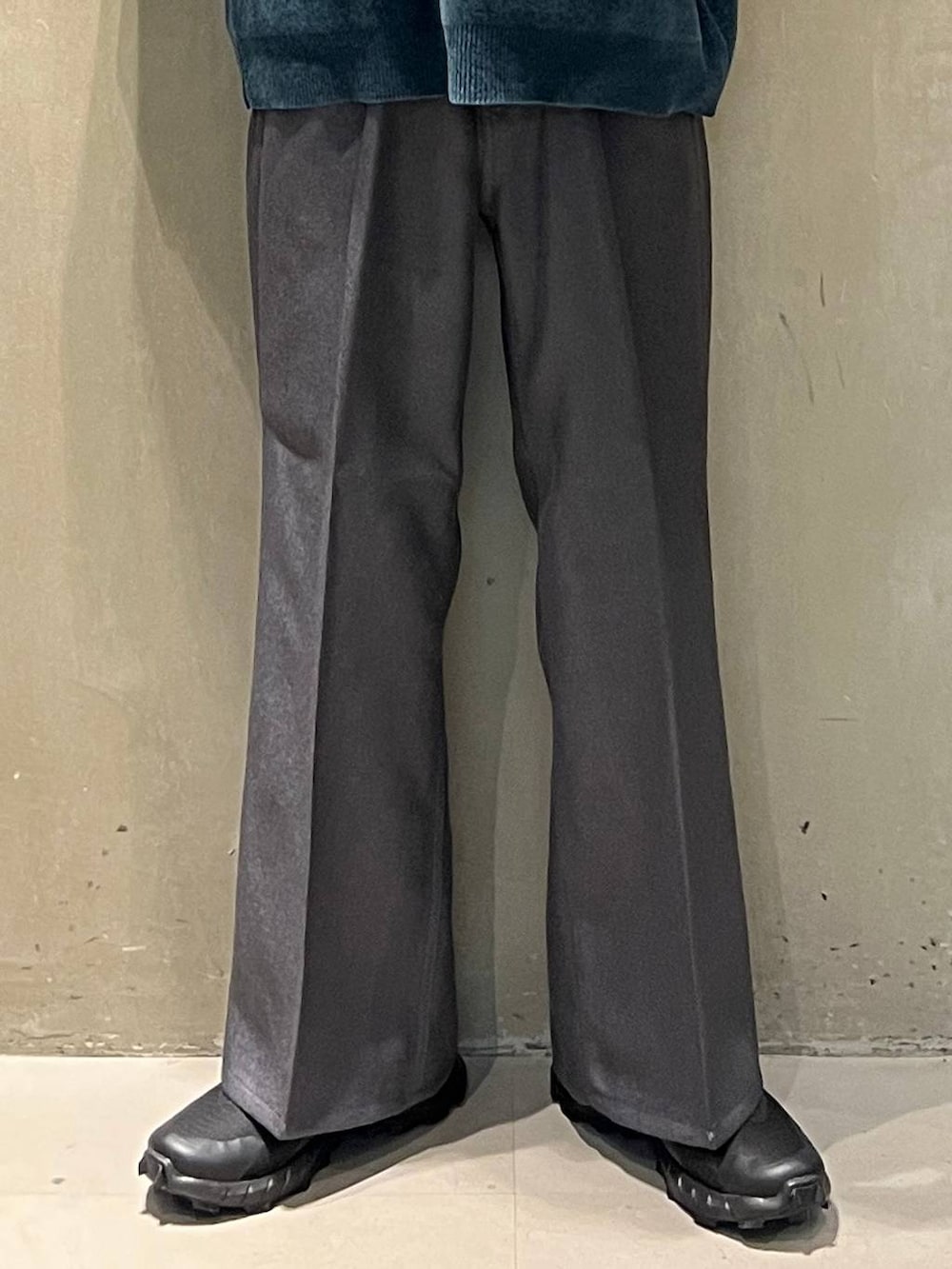 グリーン系のニット/セーター、グレー系のスラックス、ホワイト系のシャツ/ブラウスを着用したメンズの秋コーディネートの3枚目の写真