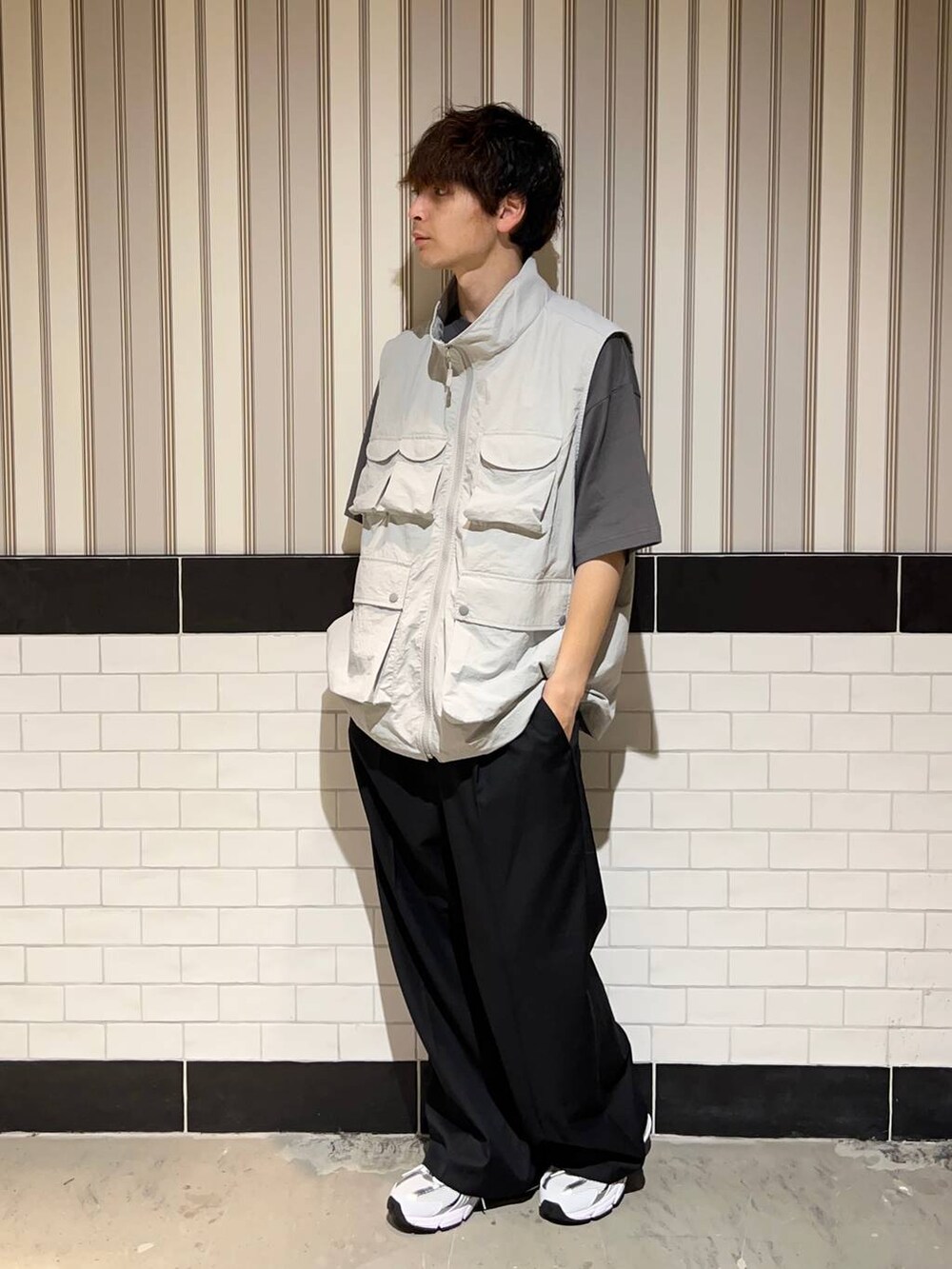 ホワイト系のスニーカー、グレー系のTシャツ/カットソー、ブラック系のスラックスを着用したメンズの夏コーディネートの2枚目の写真