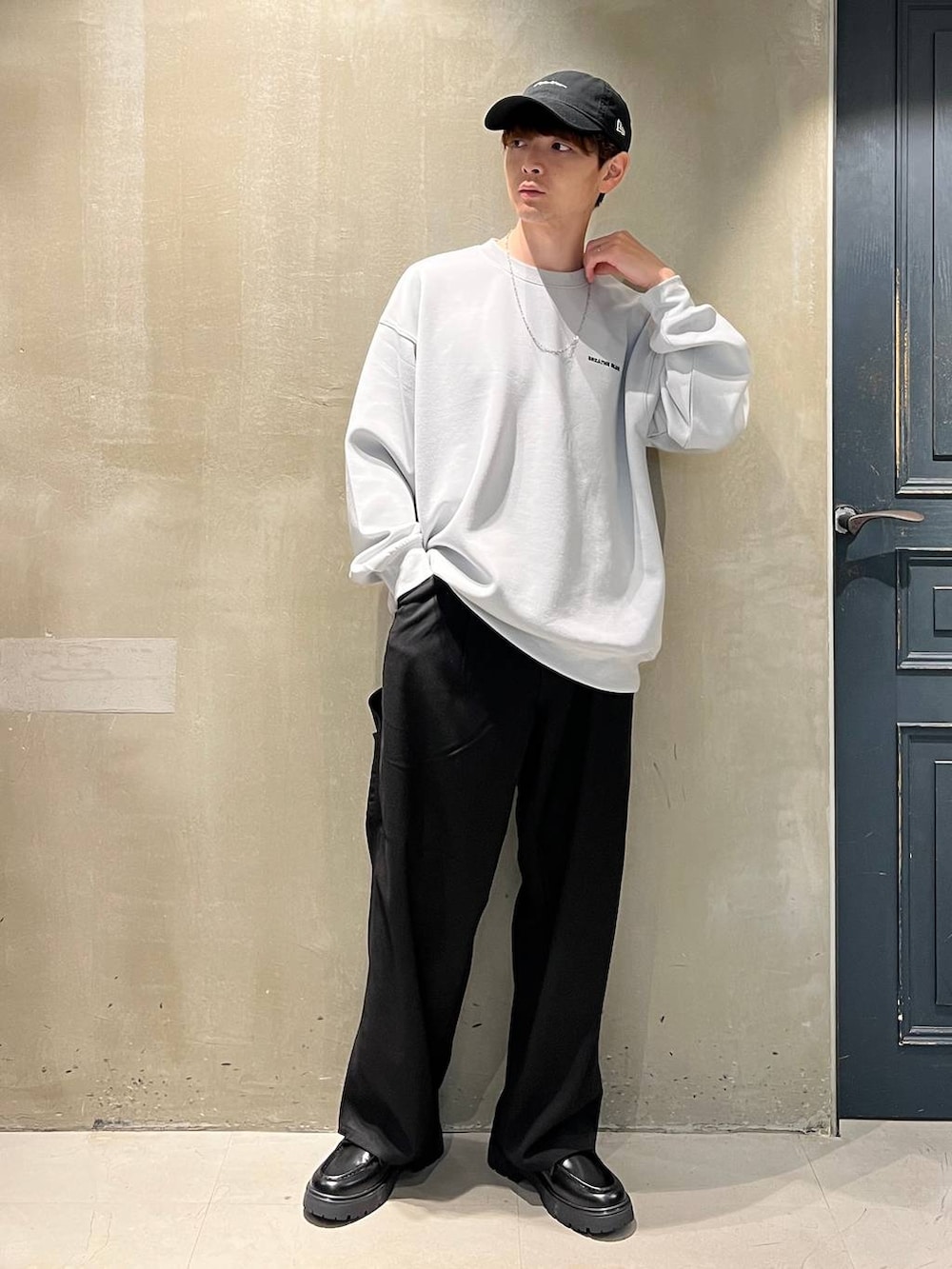 ブラック系のスラックス、グレー系のスウェット、ブラック系のキャップを着用したメンズの秋コーディネートの5枚目の写真