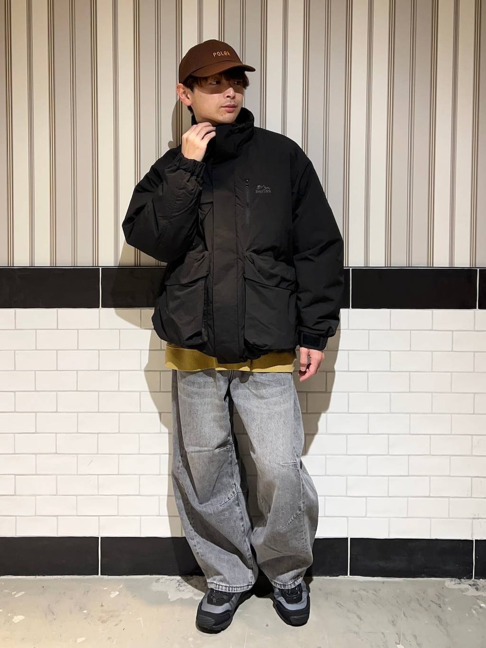 ブラック系のブルゾン、グレー系のデニムパンツ、ブラック系のスニーカーを着用したメンズの秋コーディネートの8枚目の写真