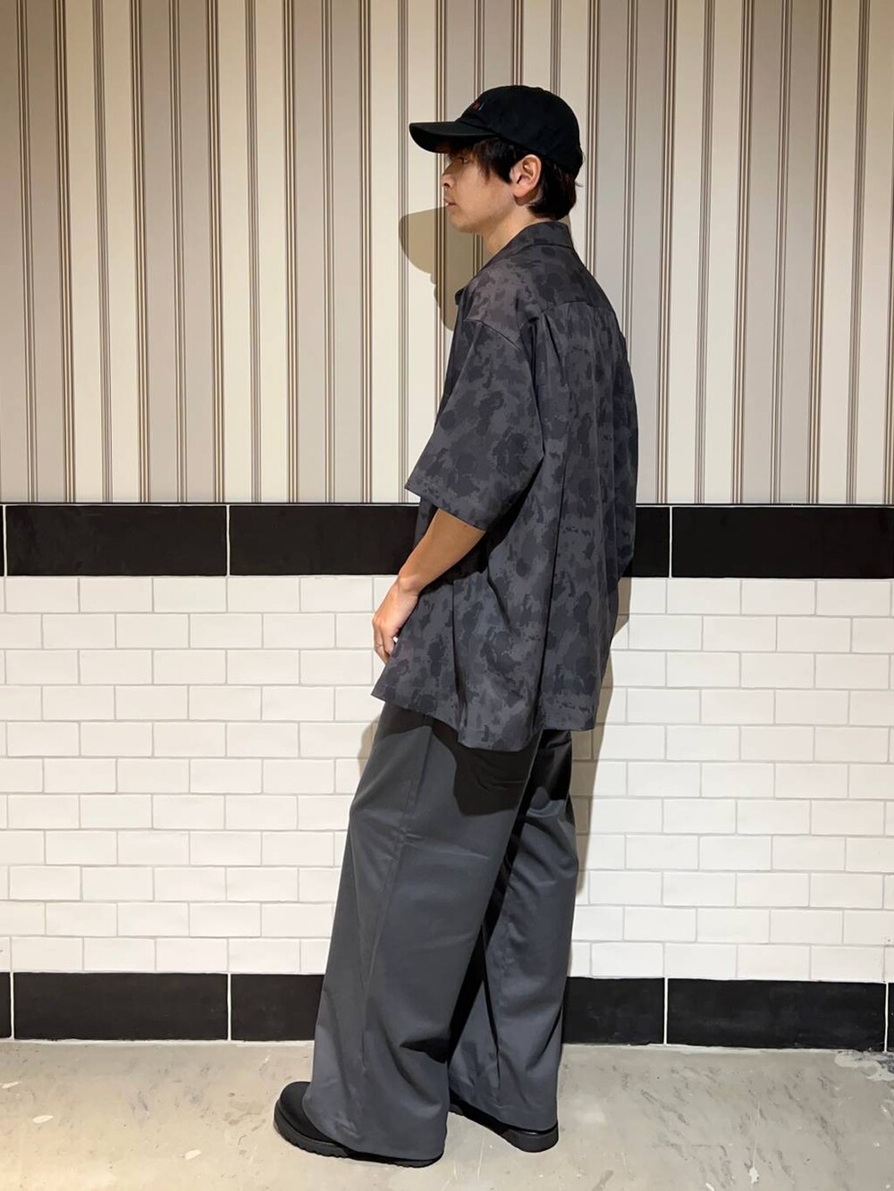 ブラック系のドレスシューズ、グレー系のスラックス、ホワイト系のTシャツ/カットソーを着用したメンズの夏コーディネートの3枚目の写真