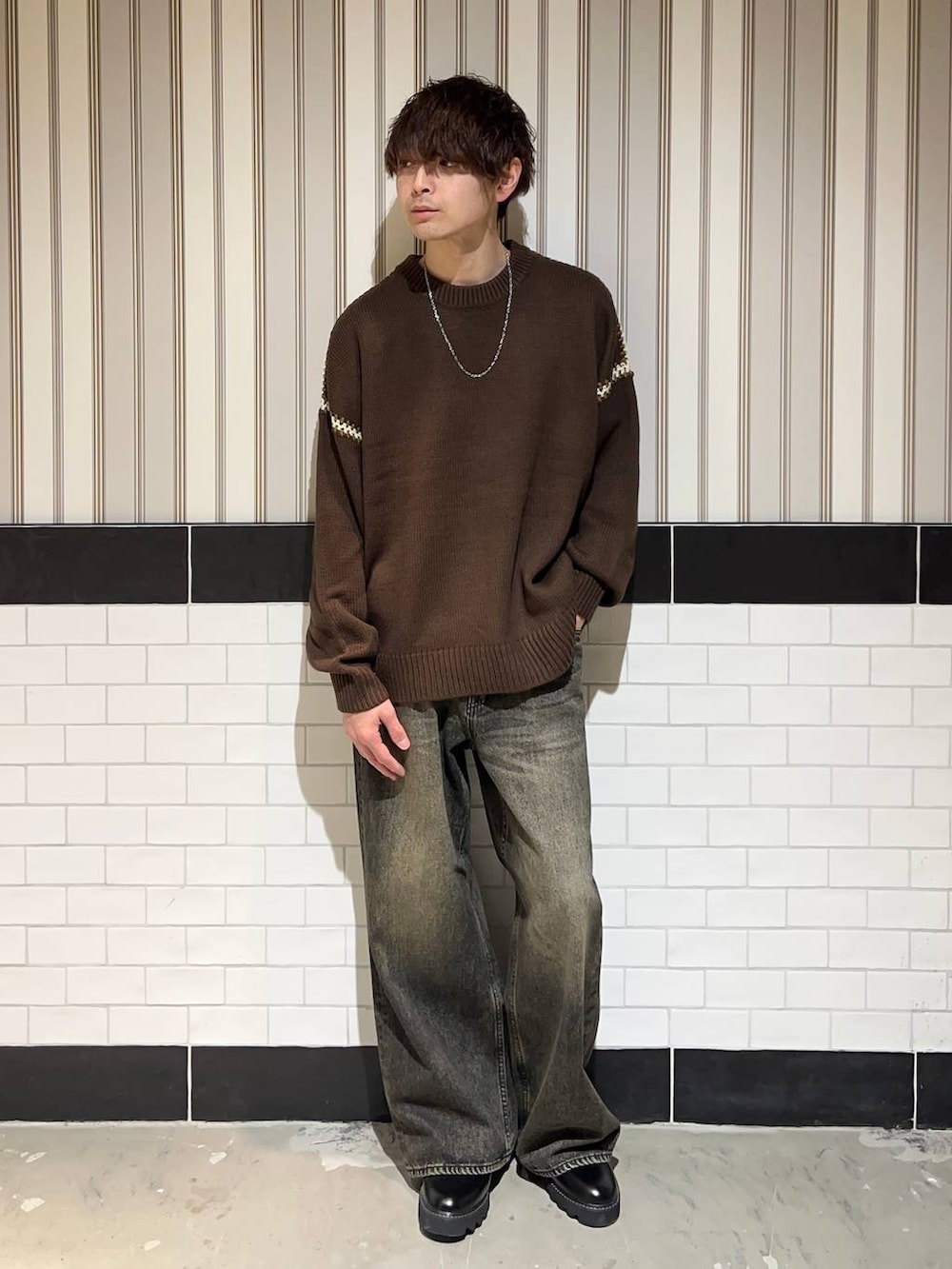 ブラック系のドレスシューズ、ブラウン系のニット/セーター、グレー系のデニムパンツを着用したメンズの冬コーディネートの2枚目の写真