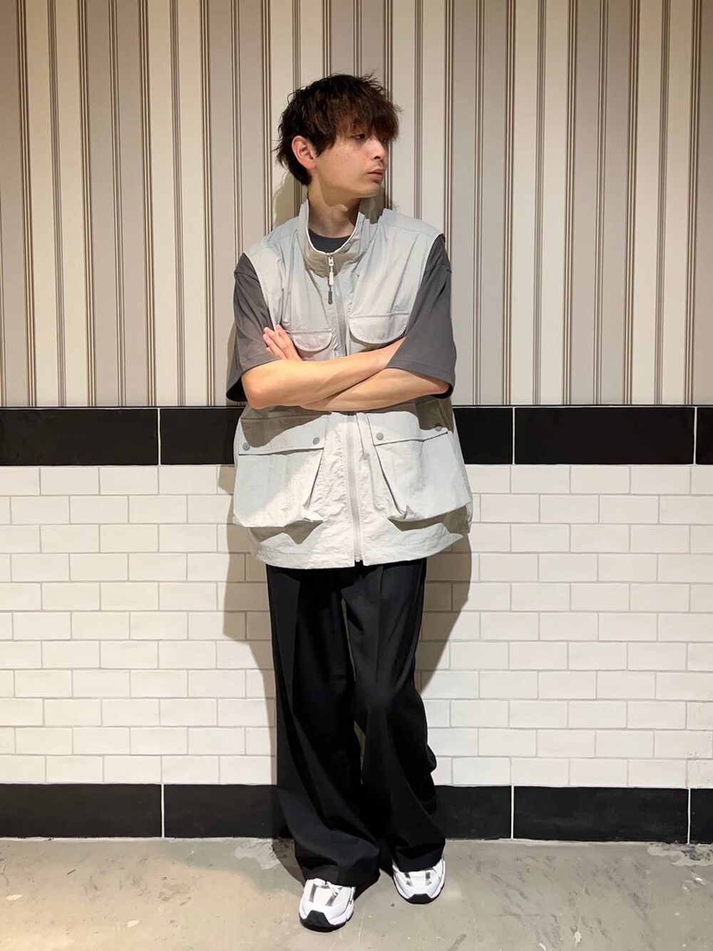 ホワイト系のスニーカー、グレー系のTシャツ/カットソー、ブラック系のスラックスを着用したメンズの夏コーディネートの6枚目の写真