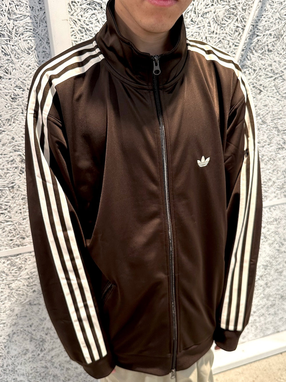 ブラウン系のジャージ、ブラック系のシューズを着用したメンズの秋コーディネートの2枚目の写真