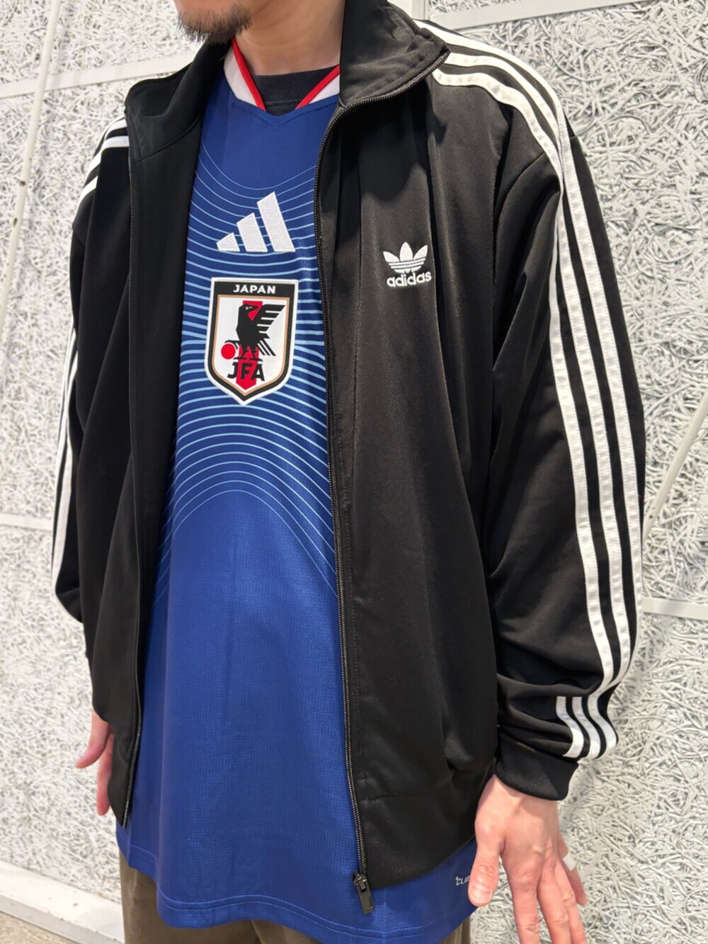 ブルー系のTシャツ/カットソー、ブラック系のスニーカー、ブラック系のトップスを着用したメンズの秋コーディネートの2枚目の写真