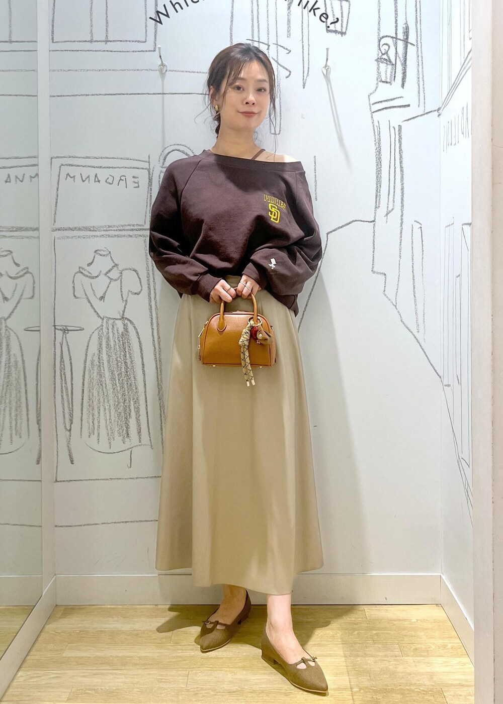 ベージュ系のスカート、ブラウン系のパンプス、ブラウン系のスウェットを着用したレディースの秋コーディネートの2枚目の写真