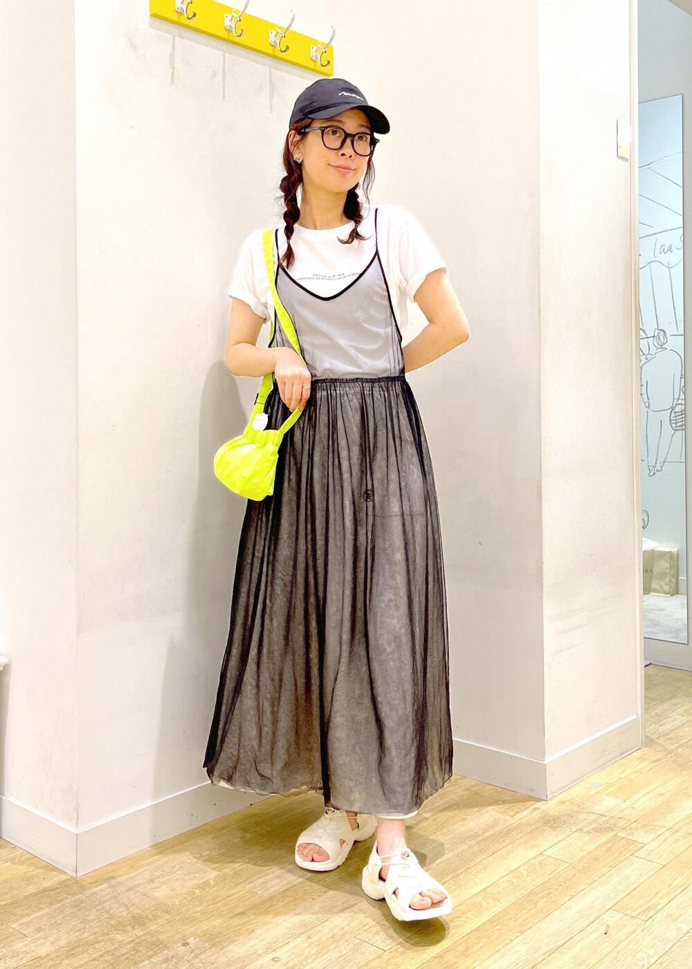 グレー系のワンピース、グリーン系のショルダーバッグ、グレー系のスカートを着用したレディースの春コーディネートの4枚目の写真