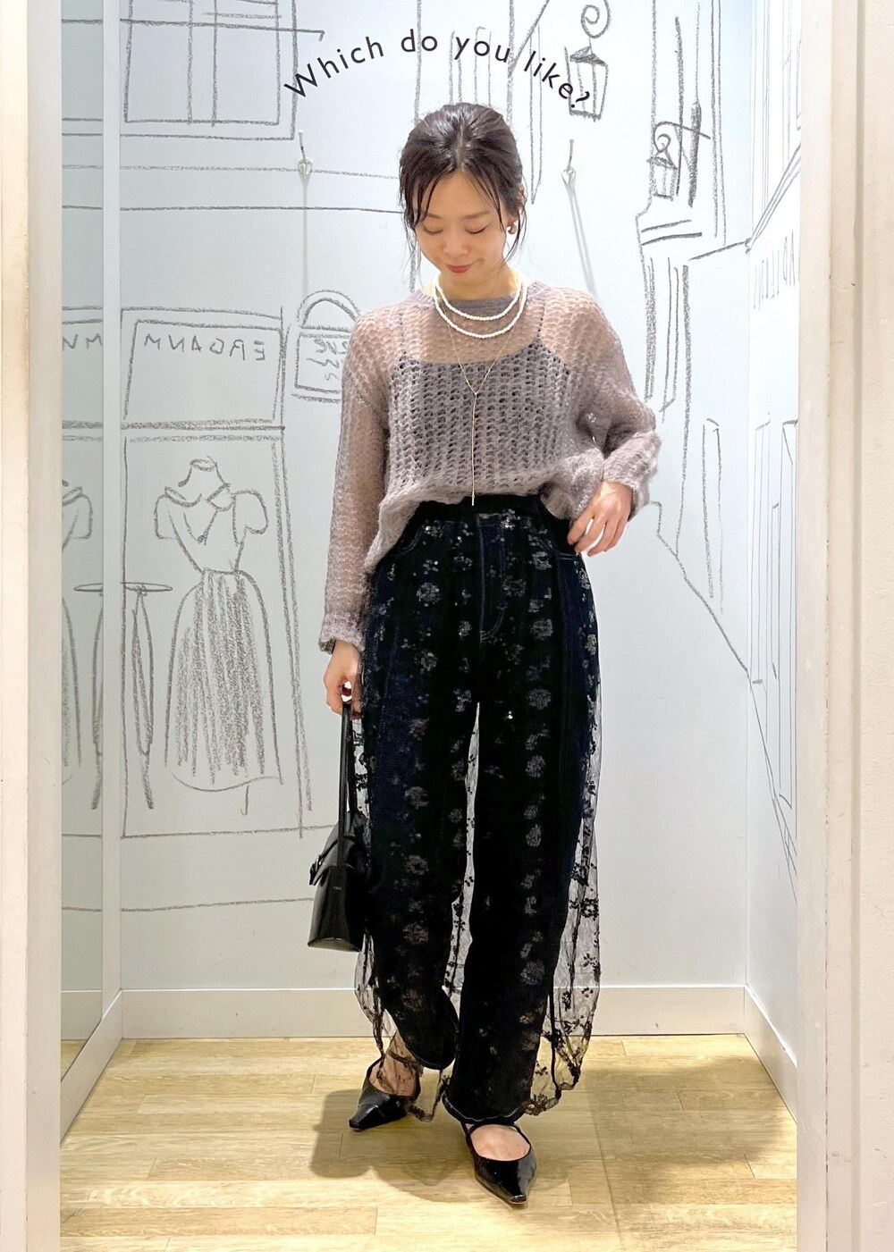 ブラック系のスカート、ブラウン系のニット/セーター、ブラック系のショルダーバッグを着用したレディースの秋コーディネートの4枚目の写真