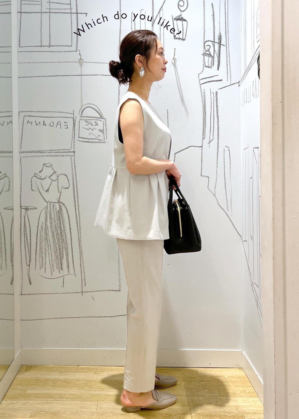 ブラック系のショルダーバッグ、グレー系のローファー、グレー系のスラックスを着用したレディースの夏コーディネートの4枚目の写真