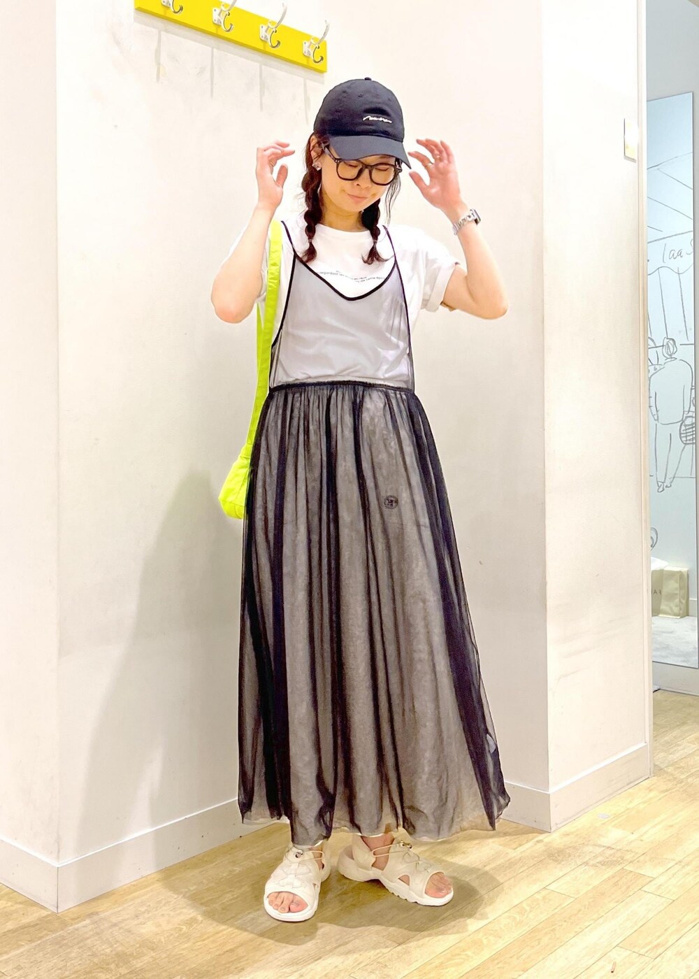 グレー系のワンピース、グリーン系のショルダーバッグ、グレー系のスカートを着用したレディースの春コーディネートの2枚目の写真