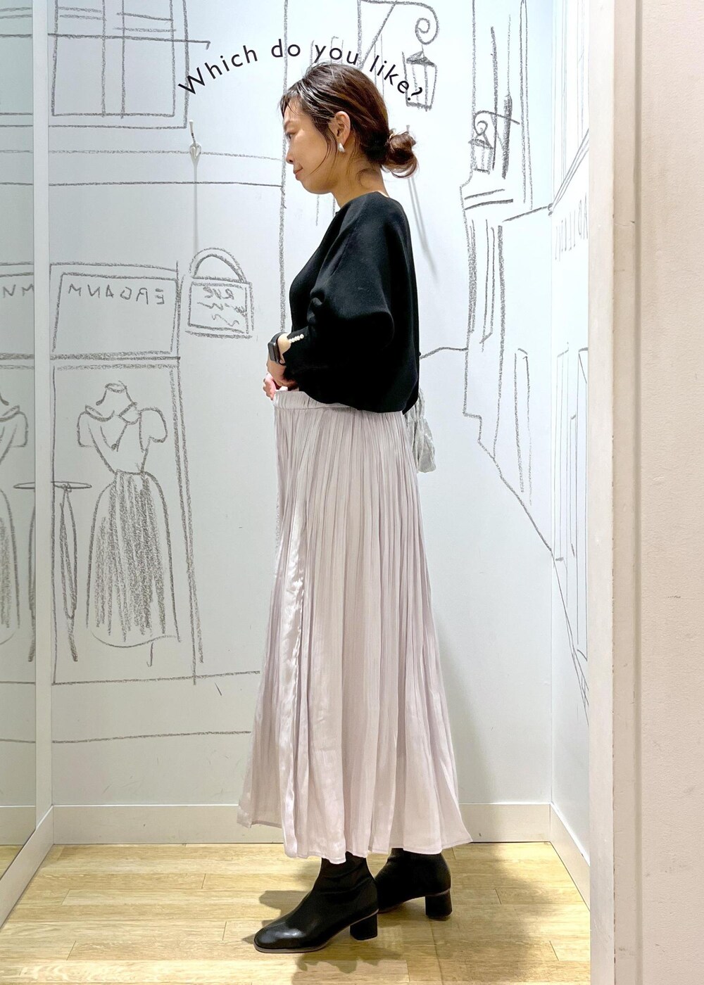 ブラック系のノーカラージャケット、ブラック系のブーツ、シルバー系のショルダーバッグを着用したレディースの冬コーディネートの3枚目の写真