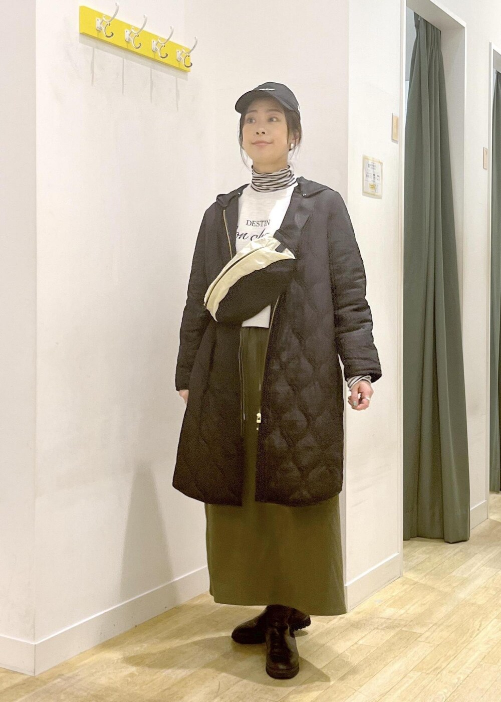 ホワイト系のTシャツ/カットソー、ベージュ系のボディバッグ/ウエストポーチ、ブラック系のその他アウターを着用したレディースの冬コーディネートの4枚目の写真