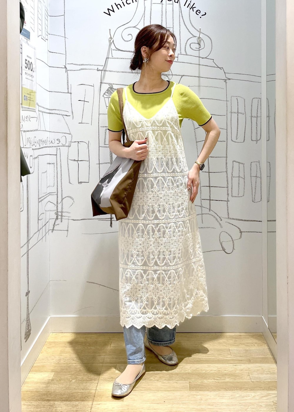 ブルー系のデニムパンツ、ホワイト系のワンピース、グリーン系のニット/セーターを着用したレディースの春コーディネートの2枚目の写真