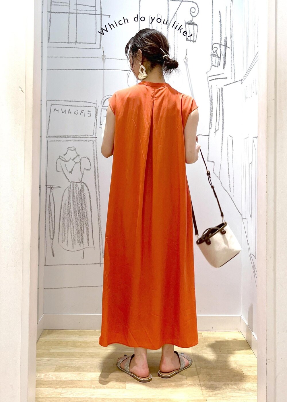 ブラウン系のトートバッグ、オレンジ系のワンピースを着用したレディースの夏コーディネートの7枚目の写真