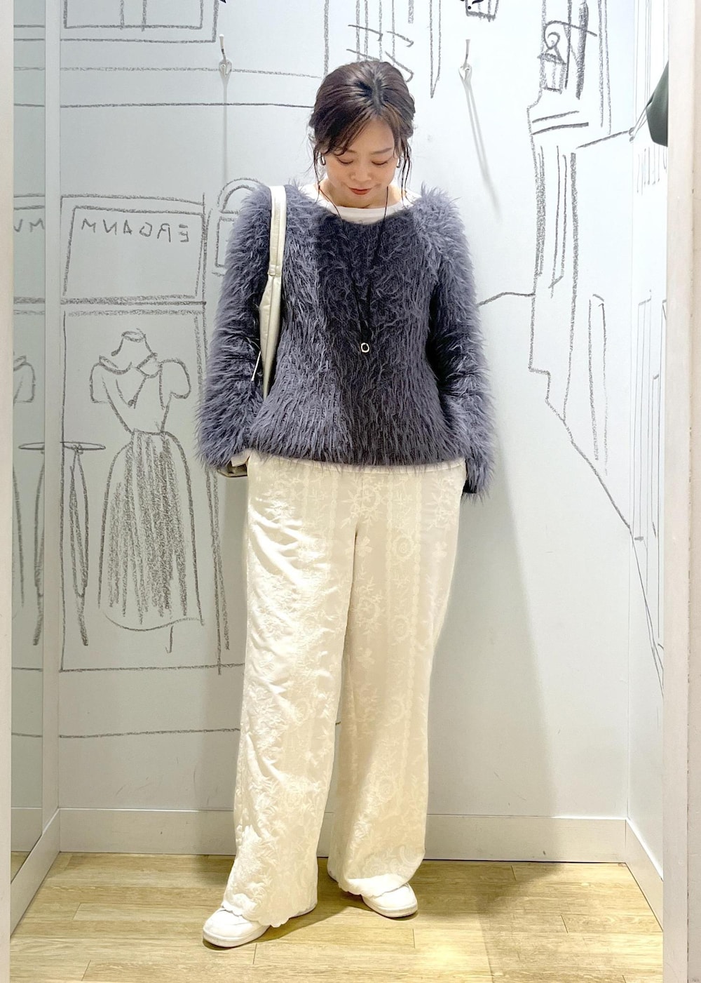 ホワイト系のスニーカー、ホワイト系のTシャツ/カットソー、グレー系のニット/セーターを着用したレディースの冬コーディネートの3枚目の写真