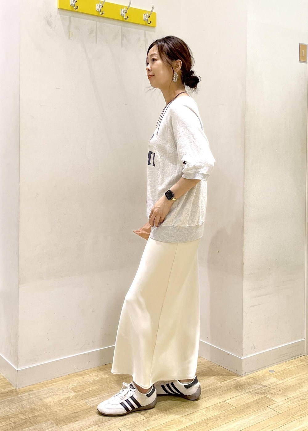 ホワイト系のスカート、グレー系のTシャツ/カットソー、ホワイト系のスニーカーを着用したレディースの夏コーディネートの6枚目の写真