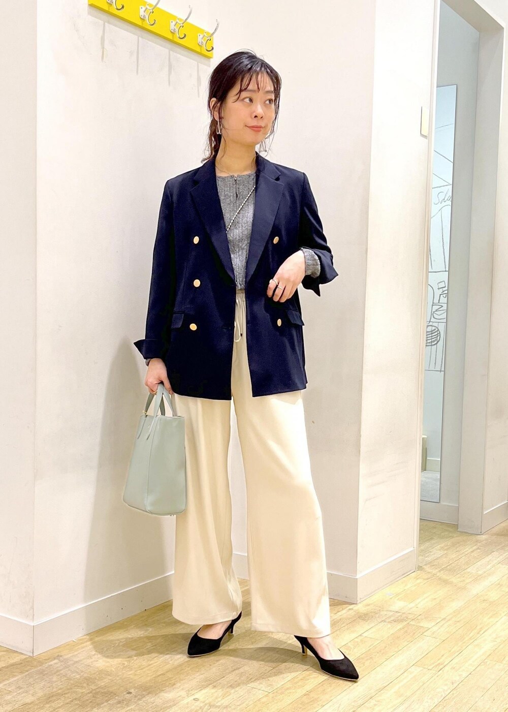 ブルー系のテーラードジャケット、ベージュ系のその他パンツ、ブラック系のニット/セーターを着用したレディースの春コーディネートの2枚目の写真