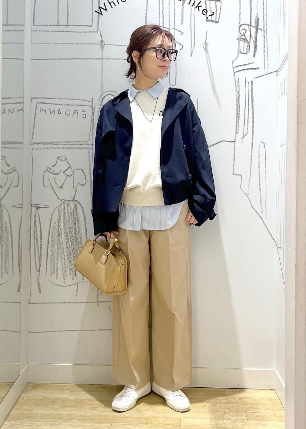 ベージュ系のボストンバッグ、ホワイト系のスウェット、ベージュ系のチノパンツを着用したレディースの春コーディネートの2枚目の写真