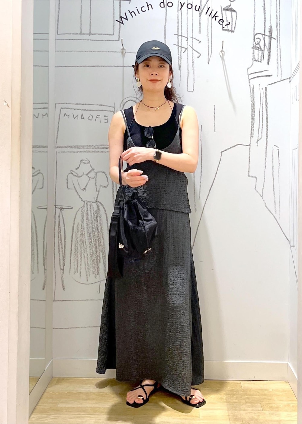 ブラック系のサンダル、ブラック系のワンピース、ブラック系のショルダーバッグを着用したレディースの夏コーディネートの2枚目の写真