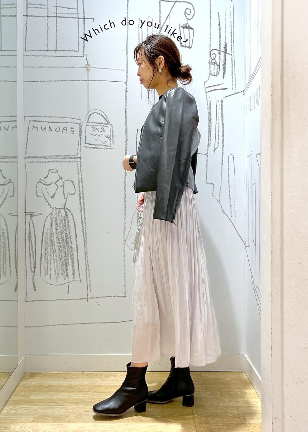 ブラック系のノーカラージャケット、ブラック系のブーツ、シルバー系のショルダーバッグを着用したレディースの冬コーディネートの8枚目の写真