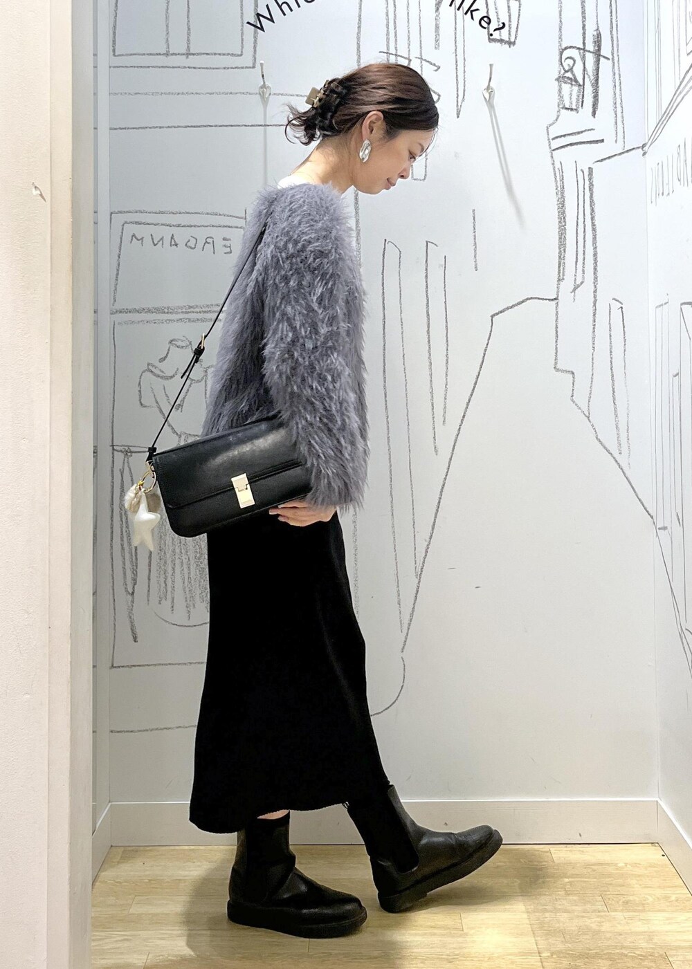 ブラック系のショルダーバッグ、ブラック系のスカート、ホワイト系のTシャツ/カットソーを着用したレディースの冬コーディネートの5枚目の写真