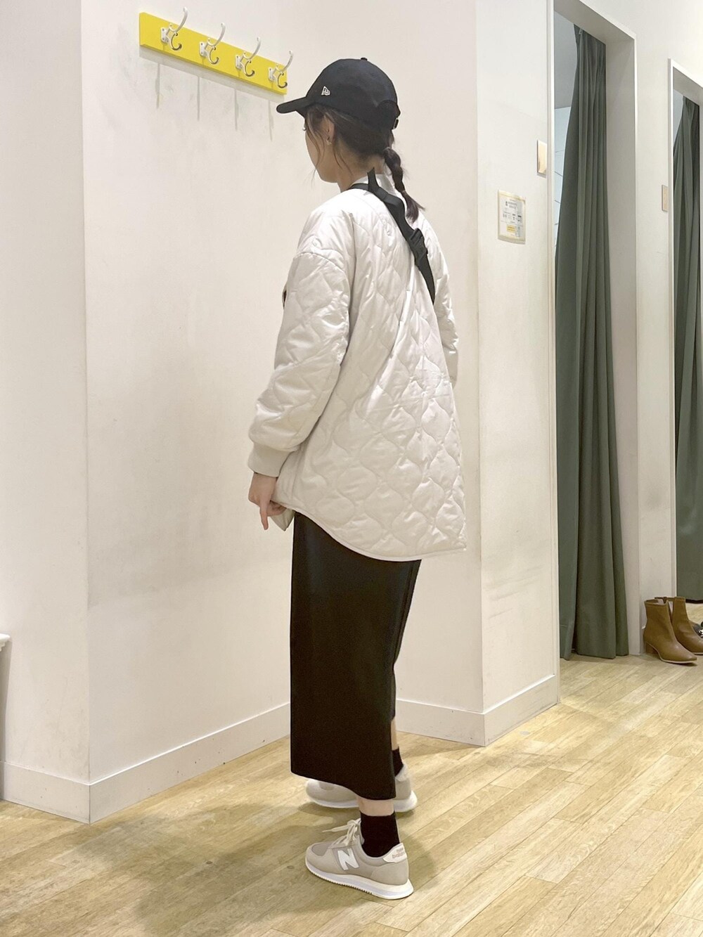 ブラック系のジャンパースカート、ブラック系のTシャツ/カットソー、ベージュ系のボディバッグ/ウエストポーチを着用したレディースの冬コーディネートの3枚目の写真