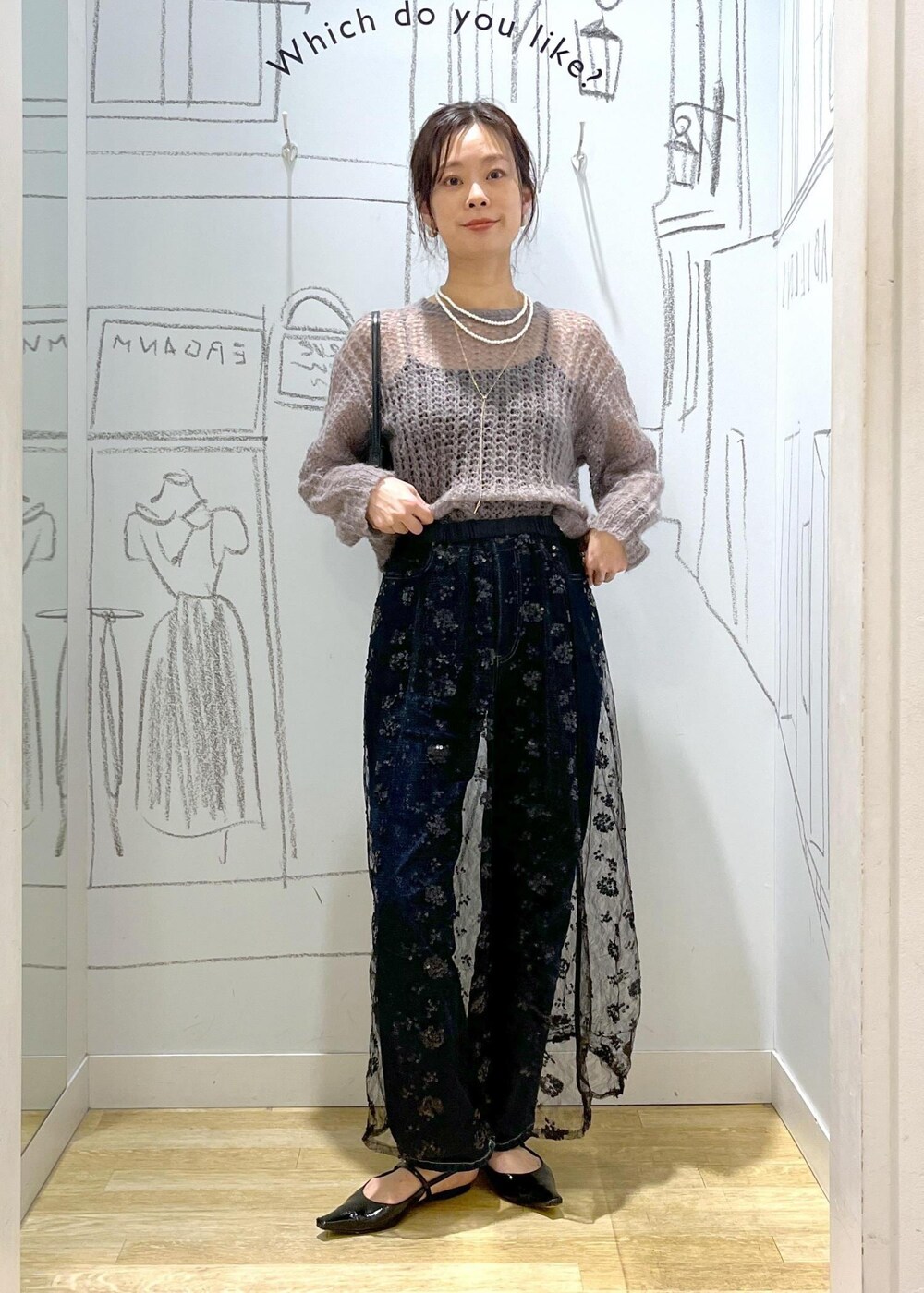 ブラック系のスカート、ブラウン系のニット/セーター、ブラック系のショルダーバッグを着用したレディースの秋コーディネートの2枚目の写真