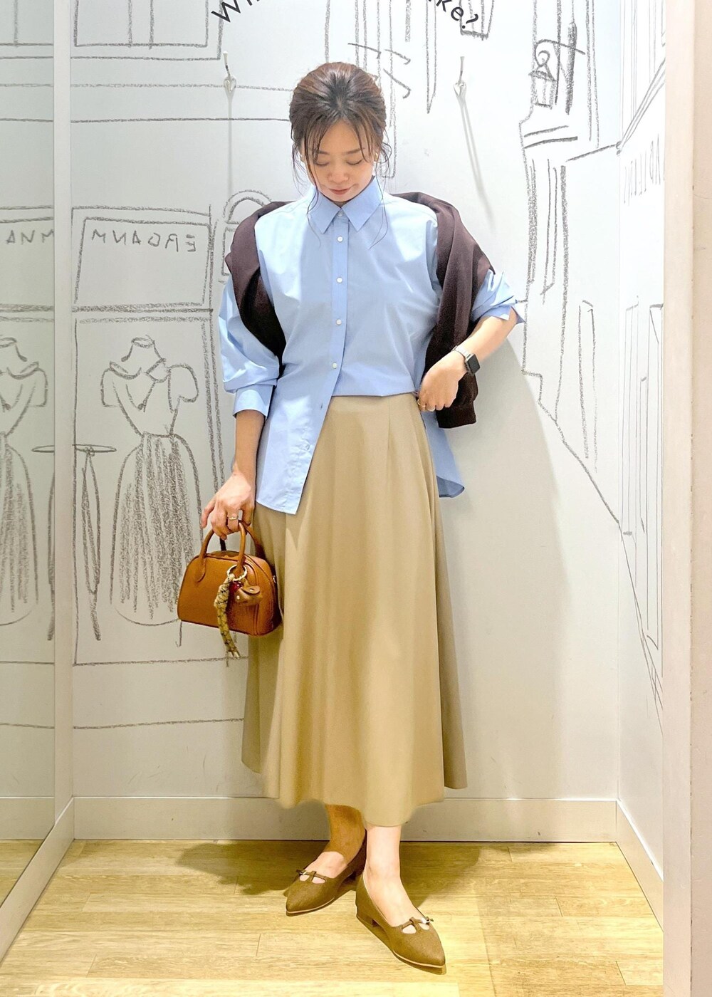 ベージュ系のスカート、ブラウン系のパンプス、ブルー系のシャツ/ブラウスを着用したレディースの秋コーディネートの3枚目の写真