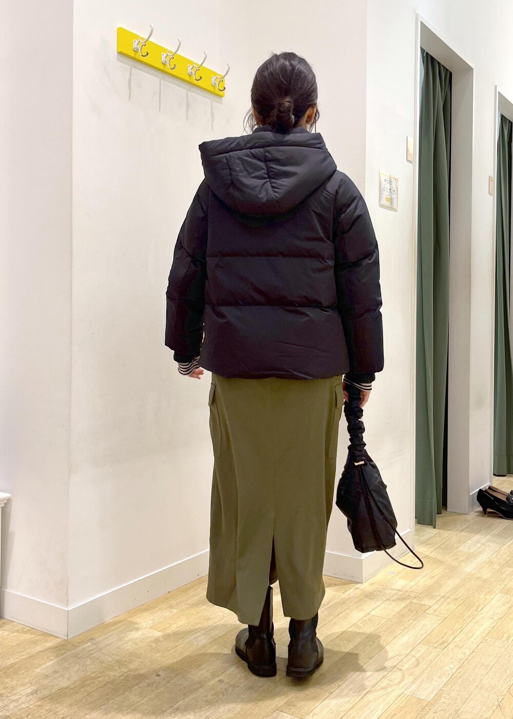 ホワイト系のTシャツ/カットソー、ブラック系のニット/セーター、ブラック系のダウンジャケット/コートを着用したレディースの冬コーディネートの3枚目の写真