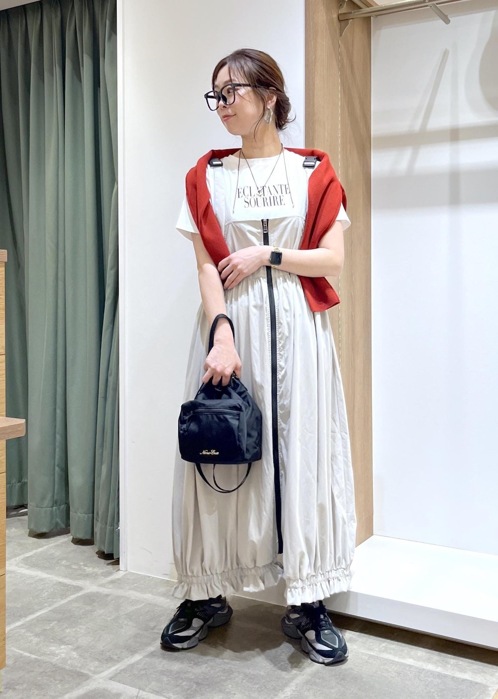 レッド系のカーディガン/ボレロ、ホワイト系のTシャツ/カットソー、グレー系のワンピースを着用したレディースの春コーディネートの2枚目の写真