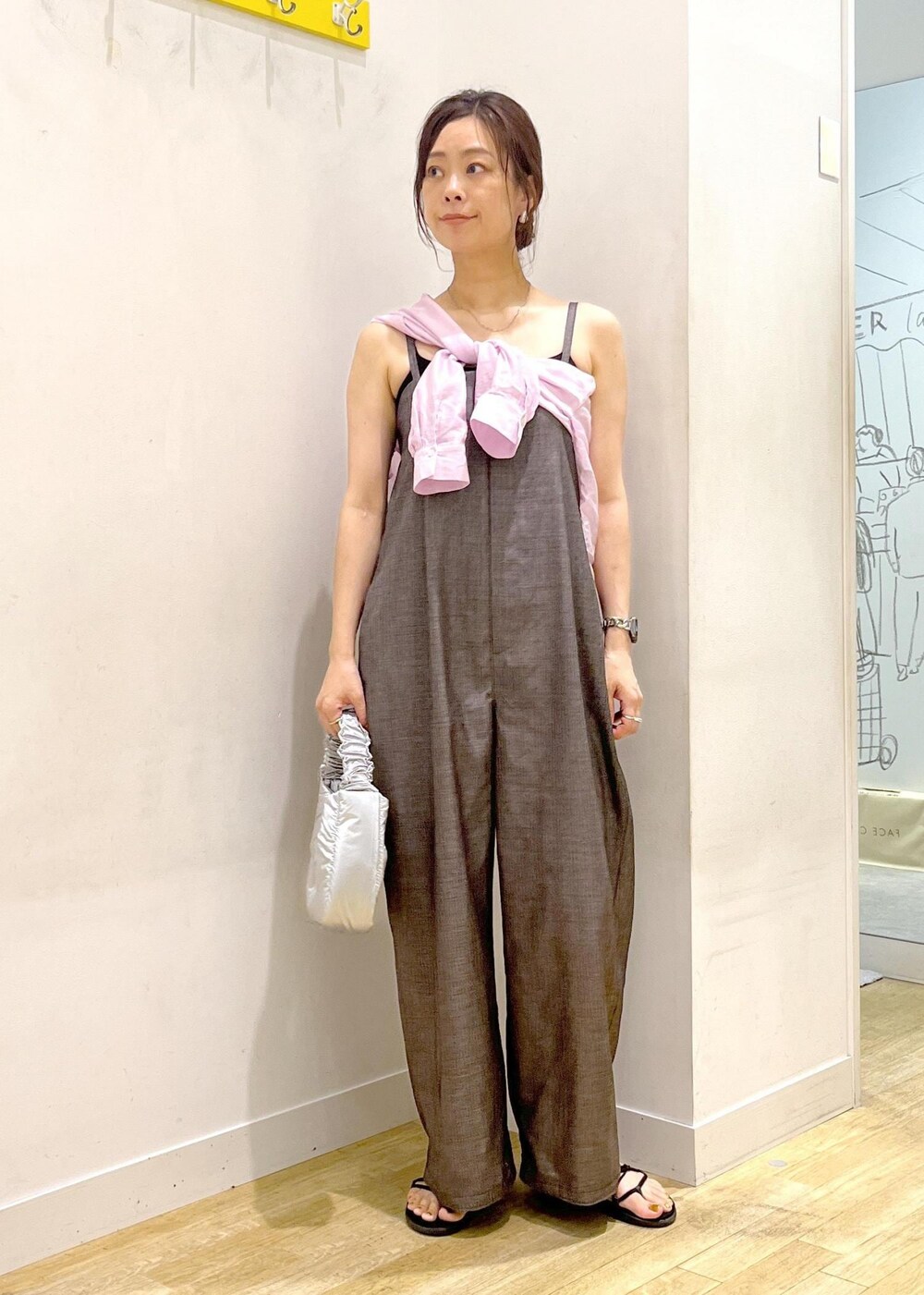シルバー系のショルダーバッグ、ピンク系のシャツ/ブラウス、グレー系のつなぎ/オールインワンを着用したレディースの夏コーディネートの2枚目の写真