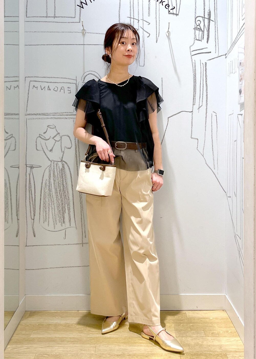 ベージュ系のチノパンツ、ブラウン系のトートバッグ、ブラック系のTシャツ/カットソーを着用したレディースの春コーディネートの4枚目の写真