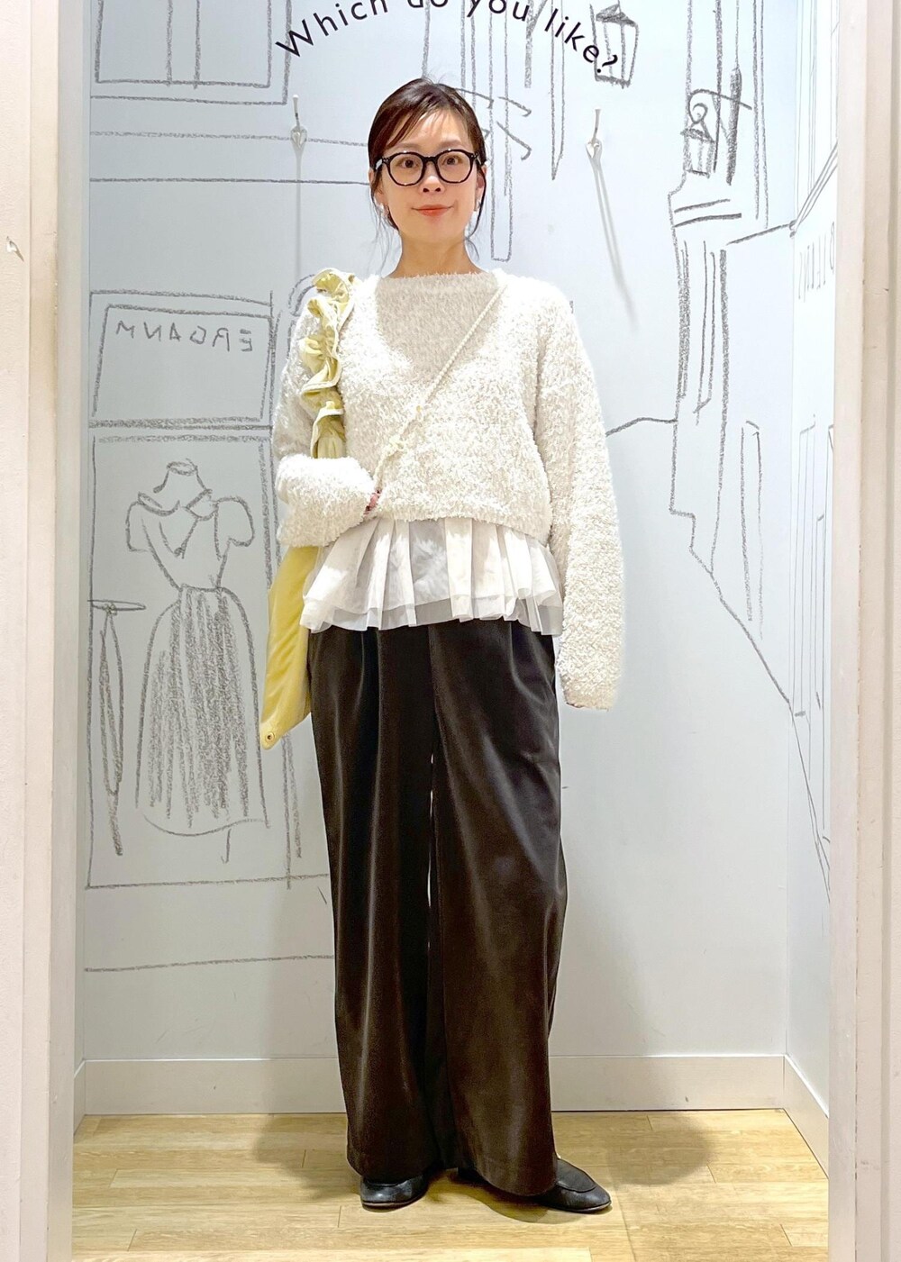 グレー系のその他パンツ、イエロー系のショルダーバッグ、ブラック系のその他アウターを着用したレディースの冬コーディネートの2枚目の写真