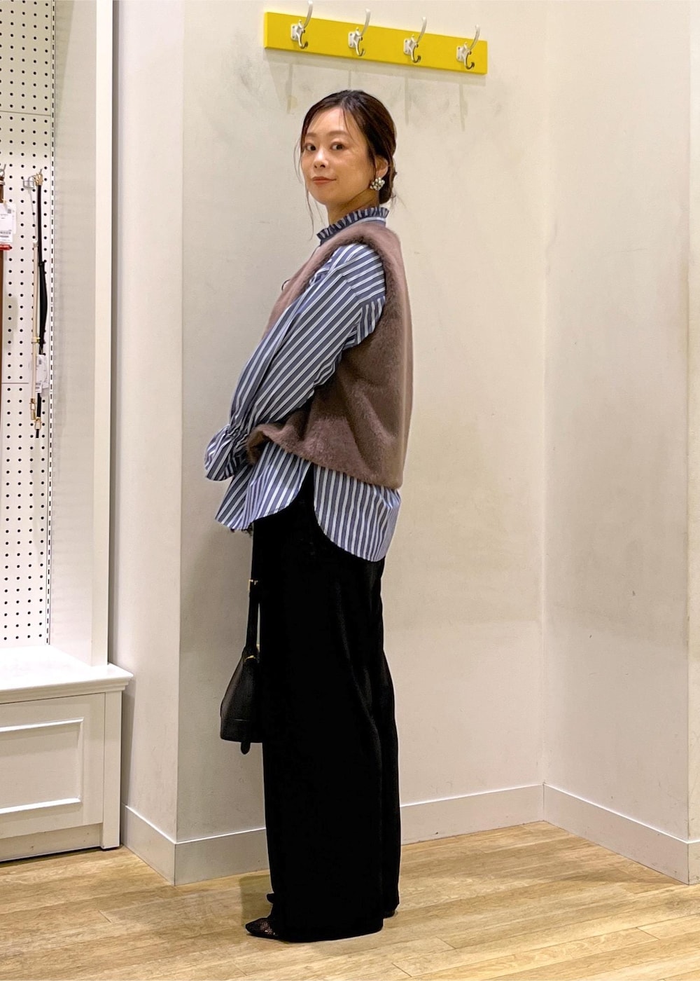 ブラック系のその他パンツ、ブラック系のショルダーバッグ、ブラウン系のベストを着用したレディースの秋コーディネートの5枚目の写真