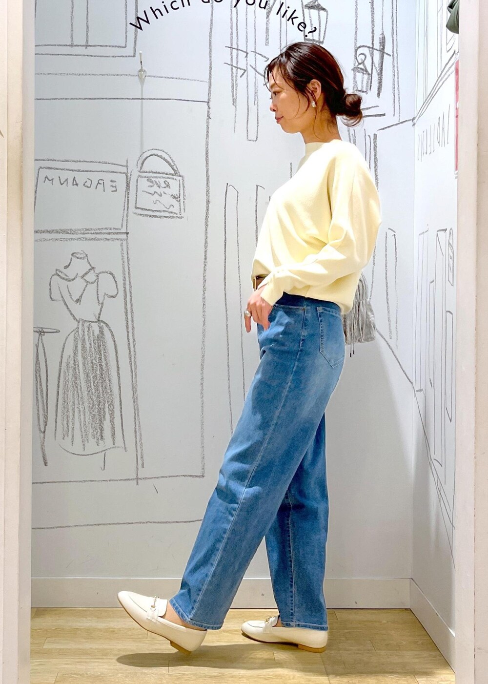 ホワイト系のマウンテンパーカー、シルバー系のショルダーバッグ、ブルー系のデニムパンツを着用したレディースの冬コーディネートの2枚目の写真