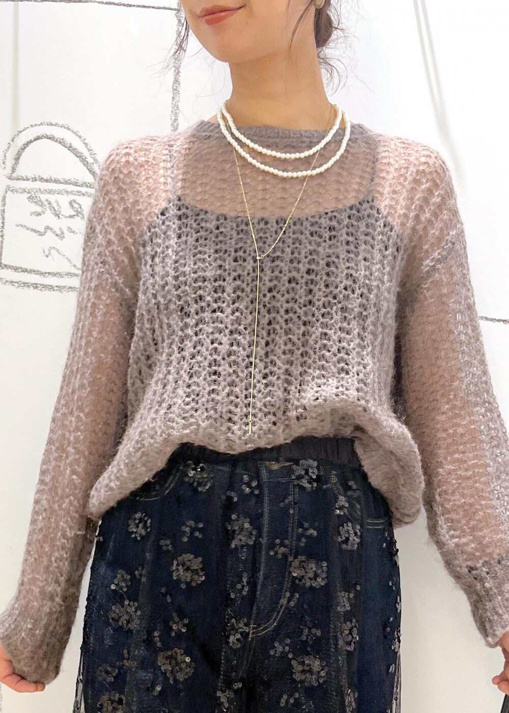 ブラック系のスカート、ブラウン系のニット/セーター、ブラック系のショルダーバッグを着用したレディースの秋コーディネートの6枚目の写真