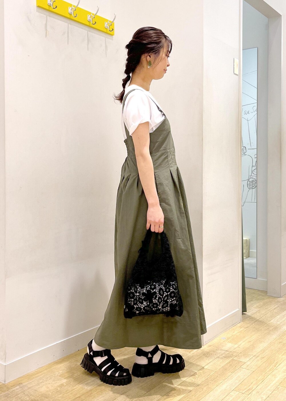 ブラック系のサンダル、グリーン系のワンピース、ブラック系のトートバッグを着用したレディースの春コーディネートの5枚目の写真