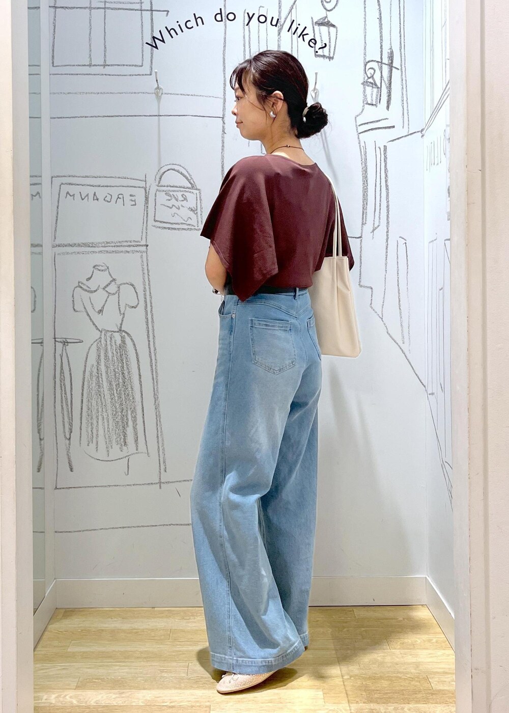 ホワイト系のトートバッグ、ブルー系のデニムパンツ、ブラウン系のニット/セーターを着用したレディースの春コーディネートの4枚目の写真