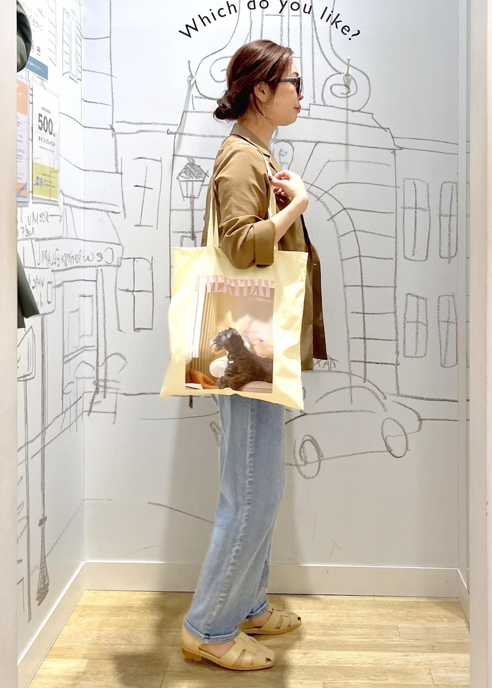ブルー系のデニムパンツ、ベージュ系のサンダル、イエロー系のテーラードジャケットを着用したレディースの春コーディネートの6枚目の写真