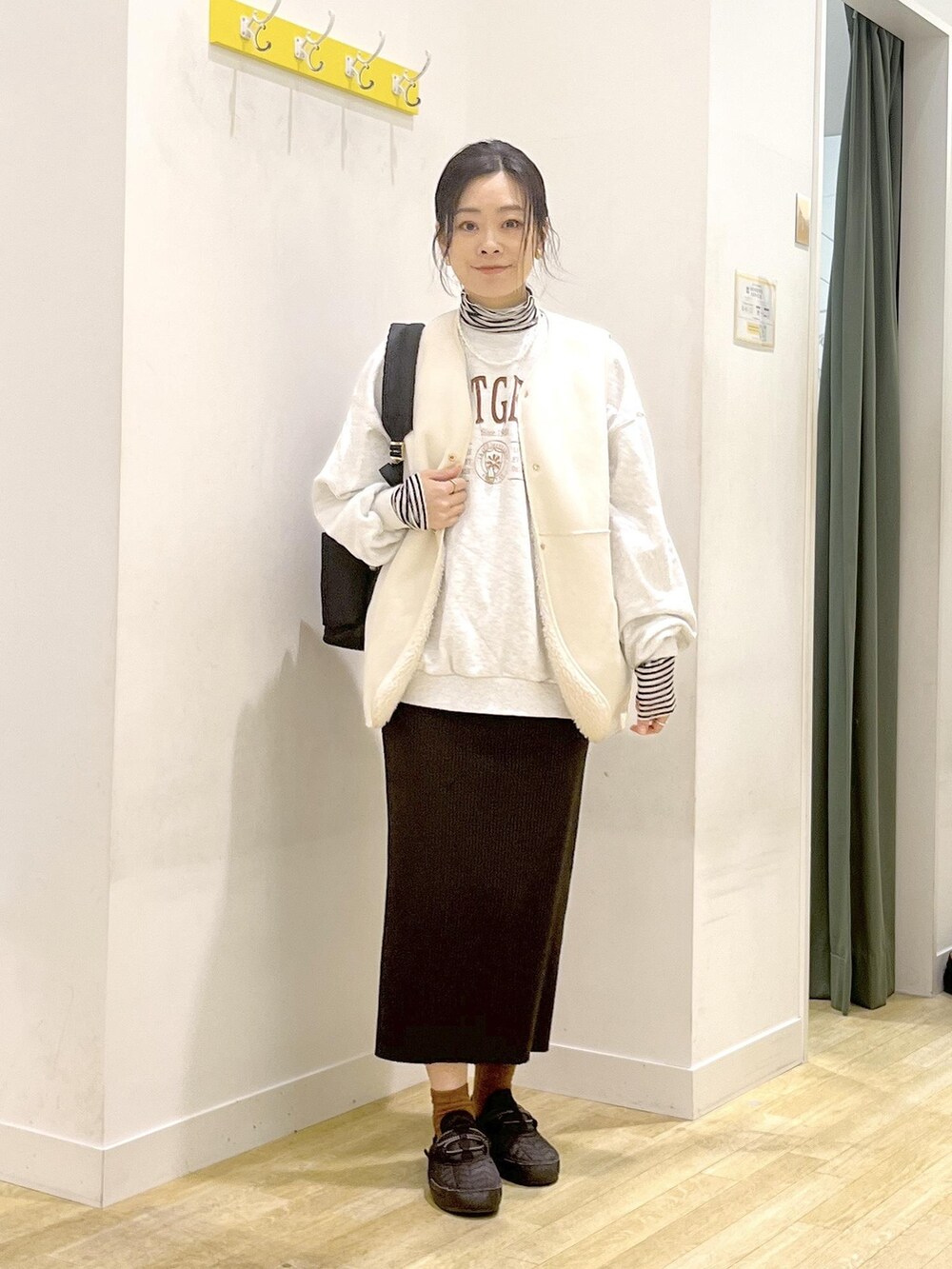 ブラック系のバックパック/リュック、ホワイト系のTシャツ/カットソー、グレー系のスウェットを着用したレディースの冬コーディネートの2枚目の写真