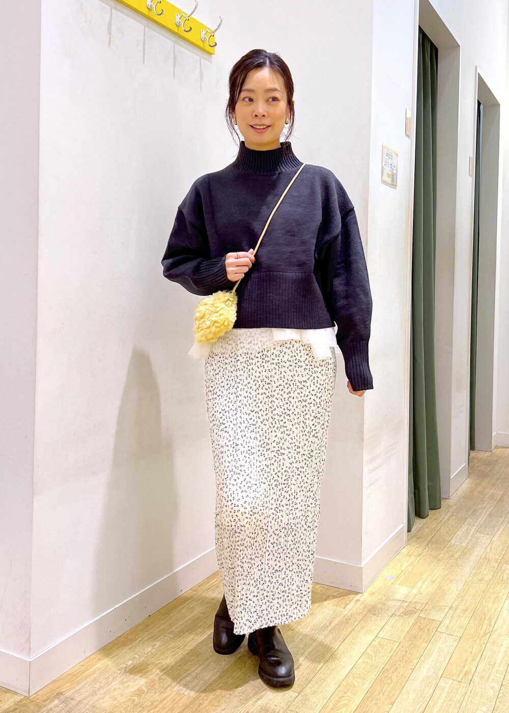 ブラック系のニット/セーター、グレー系のショルダーバッグ、ホワイト系のスカートを着用したレディースの冬コーディネートの3枚目の写真
