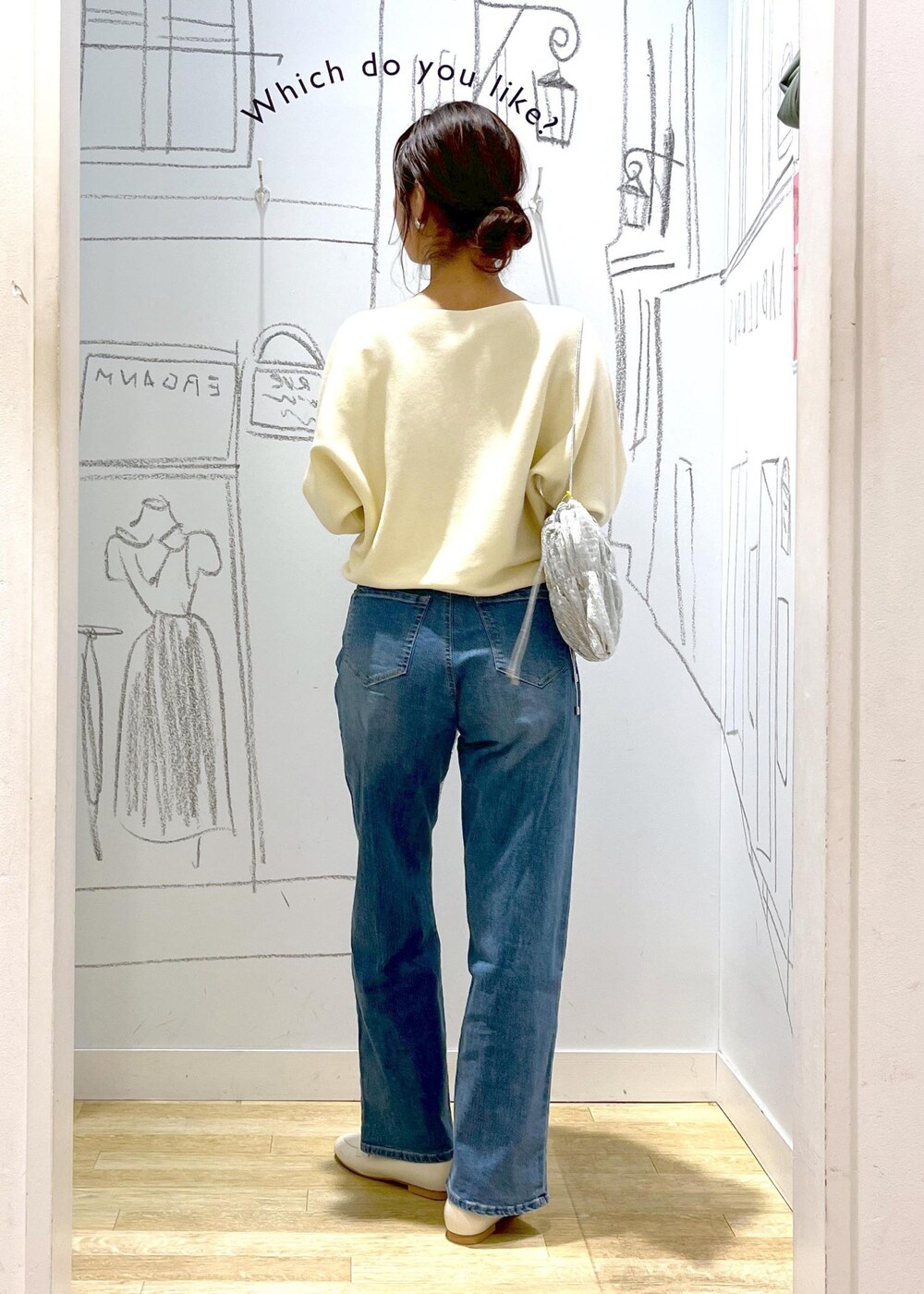 ホワイト系のマウンテンパーカー、シルバー系のショルダーバッグ、ブルー系のデニムパンツを着用したレディースの冬コーディネートの5枚目の写真