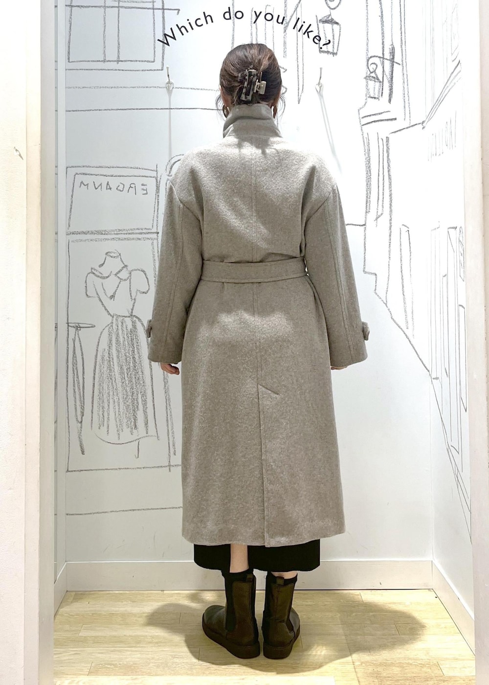 ブラック系のショルダーバッグ、ブラック系のスカート、ベージュ系のチェスターコートを着用したレディースの冬コーディネートの6枚目の写真