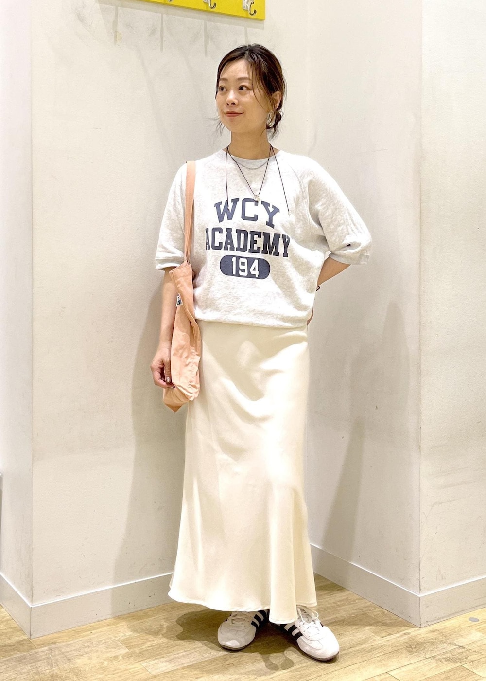 ホワイト系のスカート、グレー系のTシャツ/カットソー、ホワイト系のスニーカーを着用したレディースの夏コーディネートの2枚目の写真