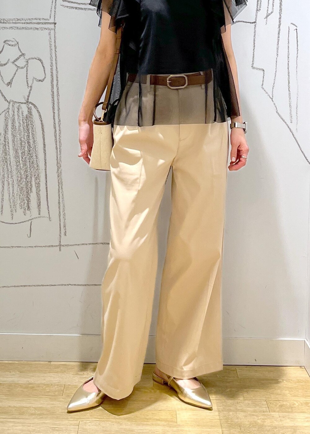 ベージュ系のチノパンツ、ブラウン系のトートバッグ、ブラック系のTシャツ/カットソーを着用したレディースの春コーディネートの10枚目の写真