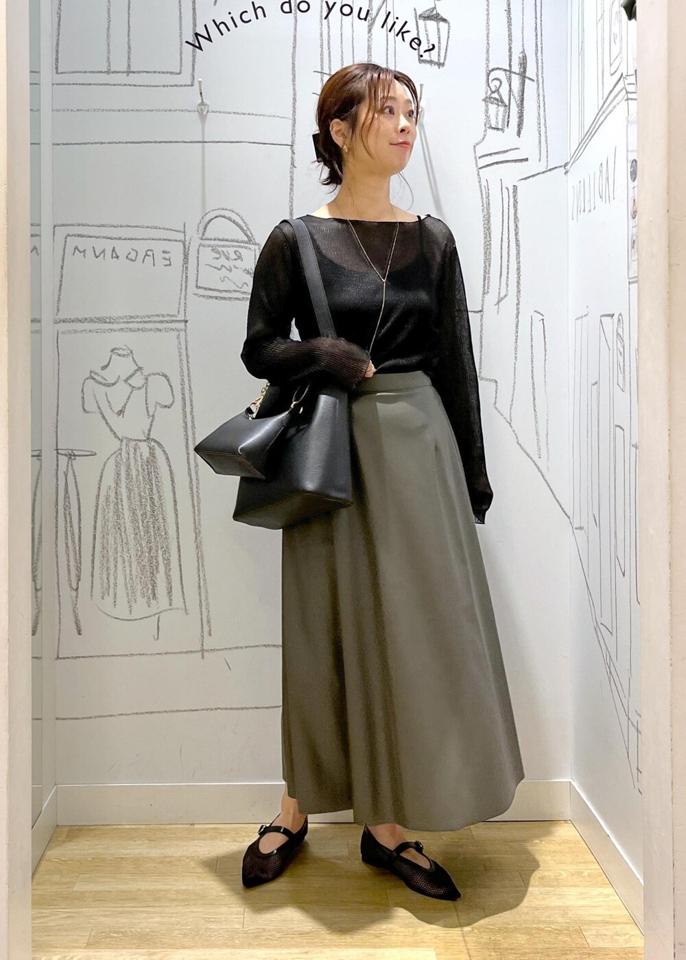 ブラック系のTシャツ/カットソー、ブラック系のショルダーバッグ、グリーン系のスカートを着用したレディースの秋コーディネートの3枚目の写真