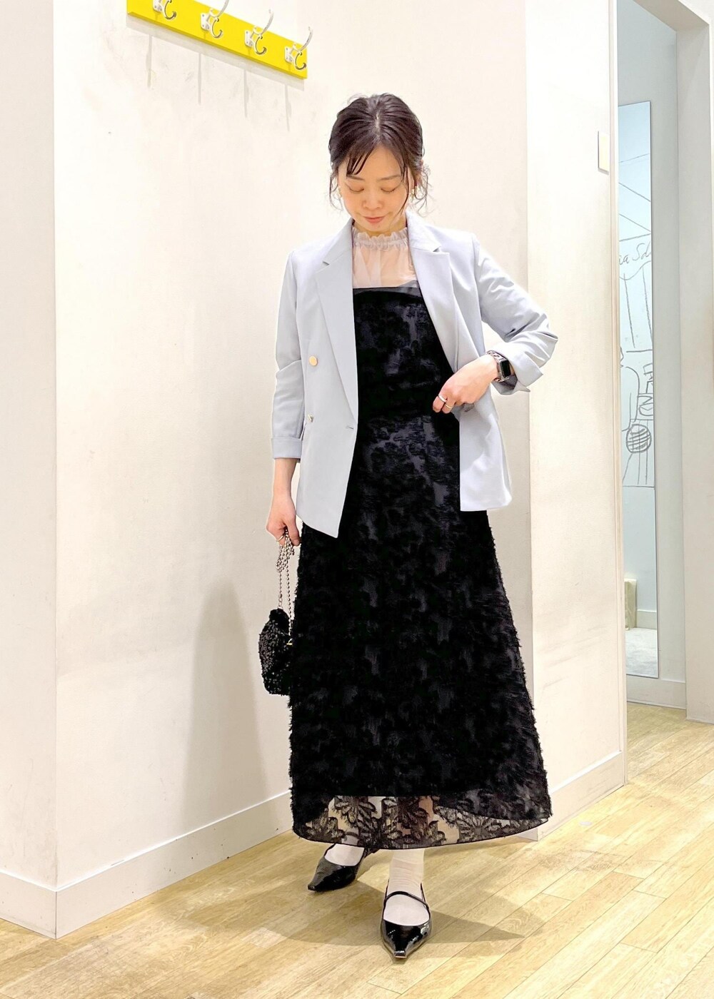 グレー系のシャツ/ブラウス、ブラック系のスカート、ブラック系のショルダーバッグを着用したレディースの春コーディネートの2枚目の写真